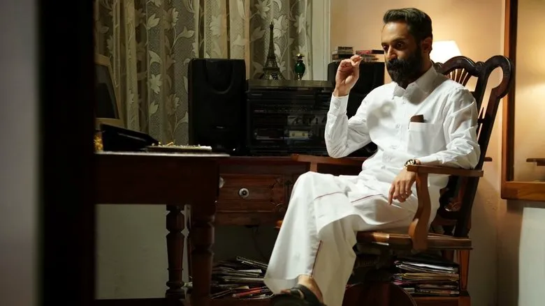 Malik movie still showing a tense confrontation in a dimly lit setting.