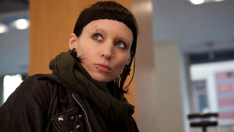 Lisbeth Salander, wearing her distinctive dark attire, crouches in a moment of reflection.
