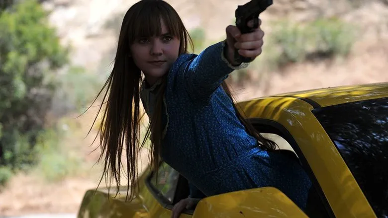 Frank teaching Roxy to handle a weapon, a poignant scene that reveals their bond in 'God Bless America'