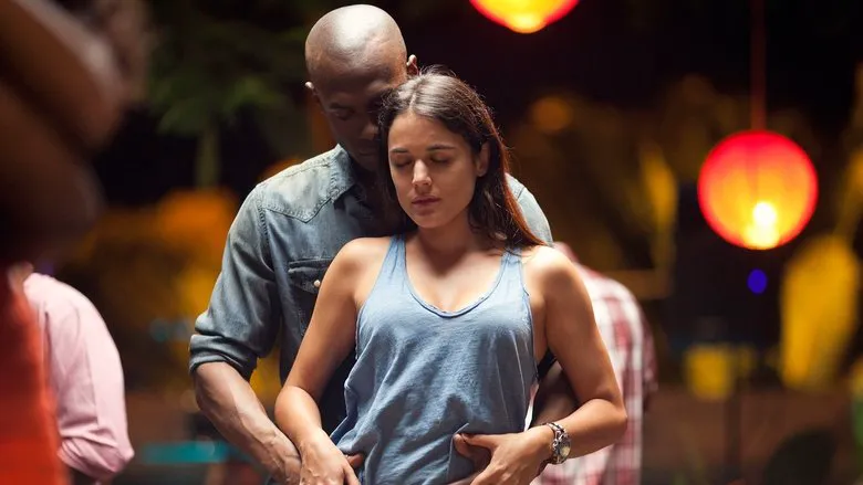 A scene showing Kilian (Mario Casas) and Bisila (Berta Vázquez) walking through a lush, green landscape, their backs to the camera, suggestive of a clandestine encounter.